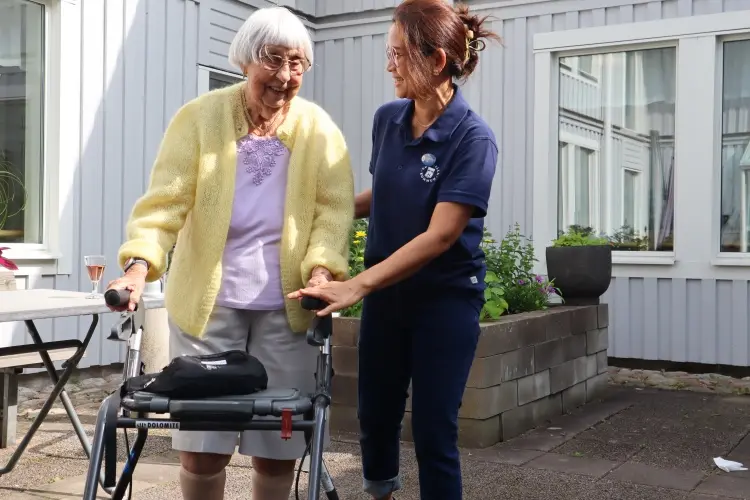Äldre kvinna på ett äldreboende med sköterska