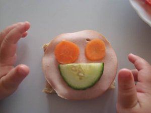 Smörgås med ögon och mun av grönsaker