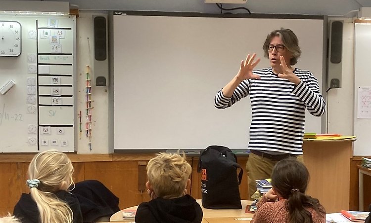 MagnusLjunggren i ett klassrum, getikulerar för eleverna.