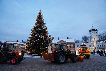 traktorer med julbelysning på Kungstorget med granen och folk tittar på