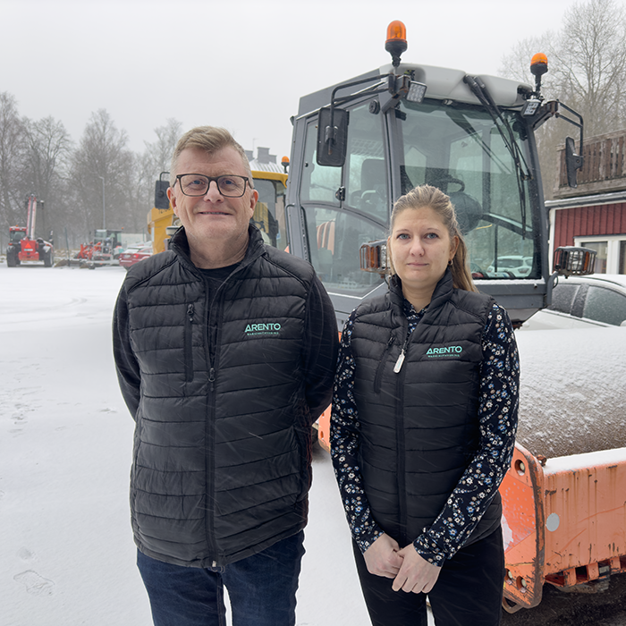 en man och en kvinna står framför en stor vält utomhus och det snöar