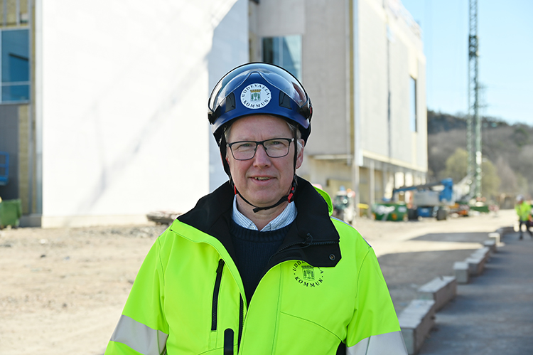 Projektledare Anders Emilsson står i gula varselkläder och blå hjälm utanför Rimnersbadet