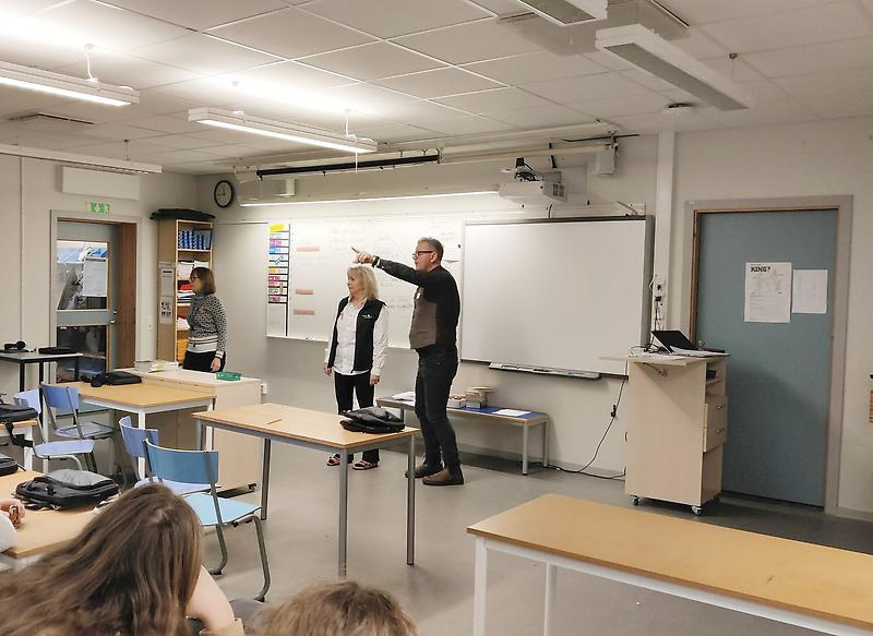 Tre personer gör rollspel i ett klassrum. 