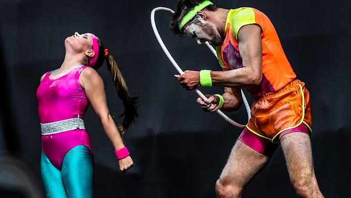 Två personer med neonfärgade träningskläder. Den ena har en rockring.