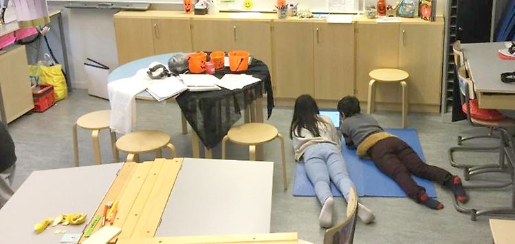 Två elever ligger på golvet och skriver en spökhistoria - på engelska!