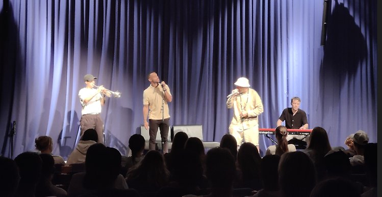 Hip hop-grupp på Bohusläns museums scen. 4 personer som sjunger och spelar